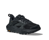 Black athletic shoe with orange Vibram logo on sole on a white background