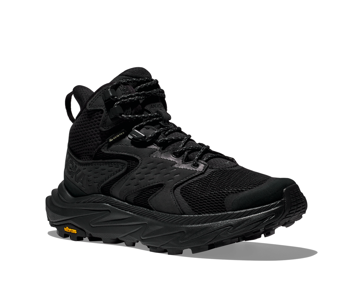 Black hiking boot with orange Vibram logo on sole on a white background