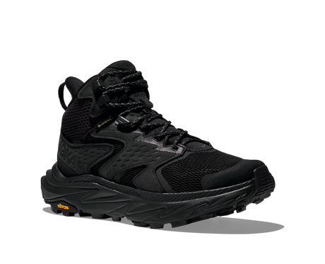 Black hiking boot with orange Vibram logo on sole on a white background