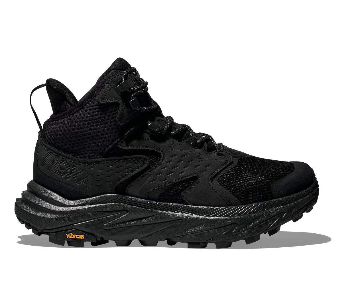 Black hiking shoe with orange Vibram logo on the sole on a white background
