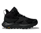 Black hiking shoe with orange Vibram logo on the sole on a white background