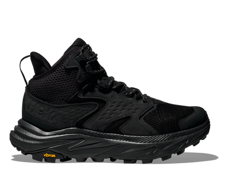 Black hiking shoe with orange Vibram logo on the sole on a white background