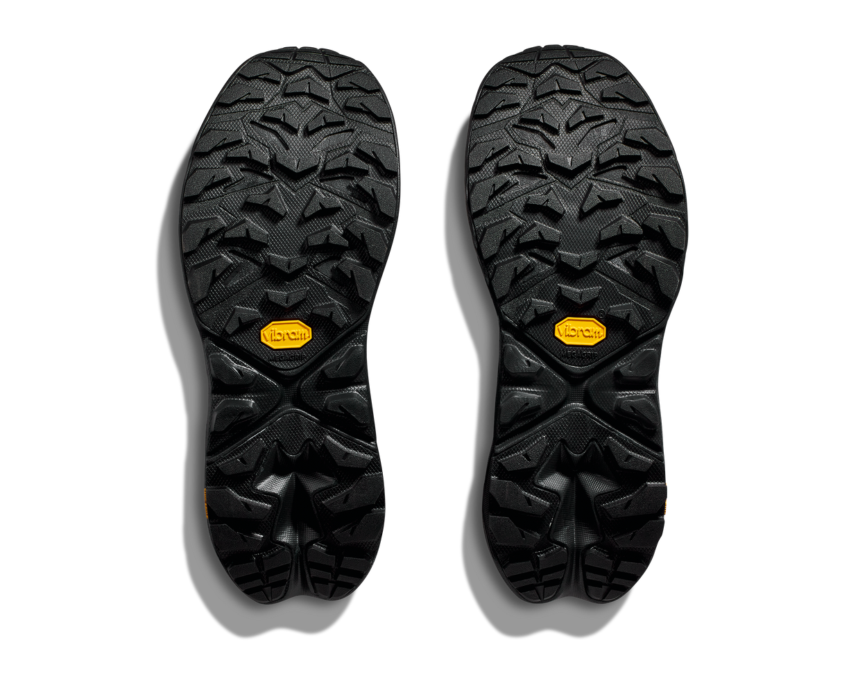 Black shoe soles with tread pattern and orange Vibram logo on a white background