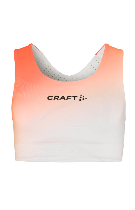 A women's sports top with a gradient of orange to white color, featuring the brand logo 'CRAFT' on the chest area.