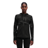 A woman wearing a black weather jacket with reflective elements on the sleeves and chest.